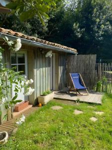 Ein blauer Stuhl steht auf einer Terrasse neben einem Zaun. in der Unterkunft Le Clos Du Gorion - Chambre d'Hôte in Montussan