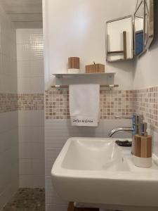 ein weißes Badezimmer mit Waschbecken und Dusche in der Unterkunft Le Clos Du Gorion - Chambre d'Hôte in Montussan