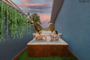 a man and a woman sitting in a bath tub at EKOSTAY - Utopian Villa with Jacuzzi in Candolim