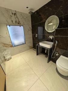 a bathroom with a toilet and a sink and a mirror at Hotel The Luxury Inn in Nāgaur +18 photos
