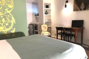 a bedroom with a bed and a desk with a computer at Denis & Virginie - château à pied - parking gratuit in Versailles