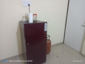 ターネーにあるPrivate Room5 At Pushpanjali Residency Ghodbunder Road Thane Westの壁の隣の部屋の小型冷蔵庫
