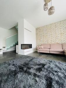 ein Wohnzimmer mit einem rosa Sofa und einem Kamin in der Unterkunft Exklusive Haushälfte zentrumsnah in Magdeburg