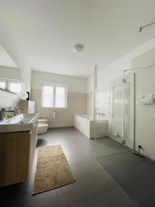 ein Badezimmer mit Dusche, Waschbecken und Badewanne in der Unterkunft Exklusive Haushälfte zentrumsnah in Magdeburg