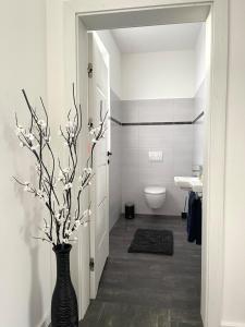 ein Badezimmer mit einer Vase mit Zweigen darin in der Unterkunft Exklusive Haushälfte zentrumsnah in Magdeburg + 7 Fotos
