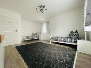 a living room with two beds and a rug at Exklusive Haushälfte zentrumsnah in Magdeburg