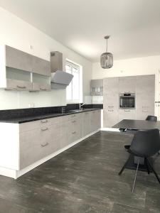 eine Küche mit weißen Schränken und einem Tisch und Stühlen in der Unterkunft Exklusive Haushälfte zentrumsnah in Magdeburg