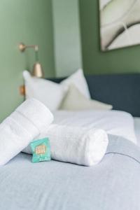 een bed met twee opgerolde handdoeken erop bij HOME1 - Belvedere Boutique Hostel in Wenen