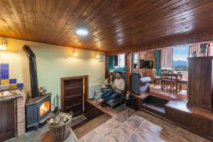 two people sitting in a living room with a fireplace at Montegrande, entorno mágico rodeado de montañas in La Plaza