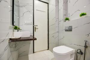 Un baño blanco con inodoro y lavabo. en Hotel Kings Inn, Karol Bagh, New Delhi, en Nueva Delhi