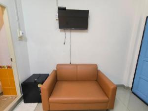 a brown couch in a room with a tv on the wall at SB Betong GUESTHOUSE in Betong +12 photos