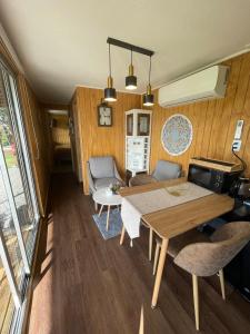 Un comedor y una sala de estar con mesa y sillas. en Cabaña moderna y equipada en parcela en Valdivia, en Valdivia