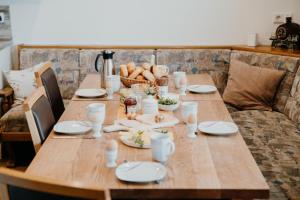 een houten tafel met borden en een mand met eten bij Berghütte Inntalblick in Erlerberg +12 foto's