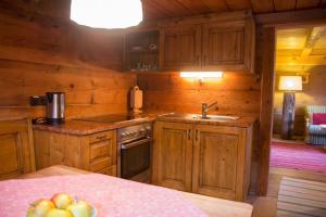 uma cozinha com armários de madeira e um lavatório numa cabina em Kuschelhütte em Neukirchen