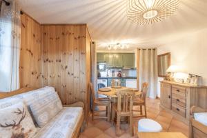 ein Wohnzimmer mit Tisch und Küche in der Unterkunft Samoëns à Pied – Appt 4 pers in Samoëns + 12 Fotos