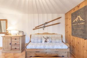 ein Schlafzimmer mit einem Bett und einer Holzkommode in der Unterkunft Samoëns à Pied – Appt 4 pers in Samoëns
