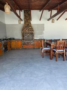 y cocina con mesa, sillas y fogones. en aylana Village, en Ponta do Ouro