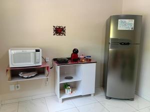 a kitchen with a refrigerator and a microwave at Campo dos Sonhos in Serra Negra