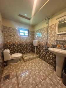 un baño con inodoro y lavabo en Crown Resort, en Skardu