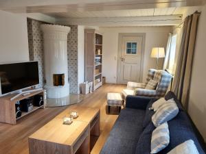 a living room with a couch and a tv at Haus Oevenum in Oevenum