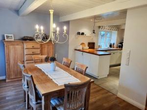 a kitchen and dining room with a wooden table and chairs at Haus Oevenum in Oevenum