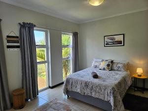 Un dormitorio con una cama y una ventana grande. en Spacious Family 2-Bedroom Apartment, en Port Alfred 5 fotos más