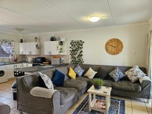 Una sala de estar con un sofá y una cocina. en Spacious Family 2-Bedroom Apartment, en Port Alfred