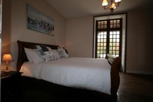a bedroom with a large white bed with a window at Maison De Lafenestre in Saint-Maigrin