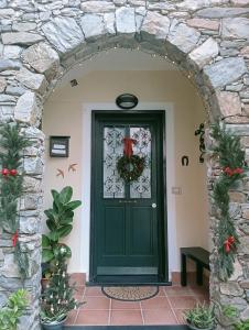 a green door with a christmas wreath on it at CASA L'UNICORNO con giardino privato in Levanto