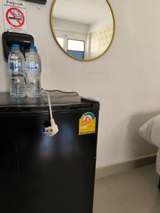 two bottles of water sitting on top of a refrigerator at SB Betong GUESTHOUSE in Betong