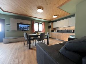 Una sala de estar con mesa de comedor y una cocina. en Bait da Nicolin - Myholidaylivigno, en Livigno