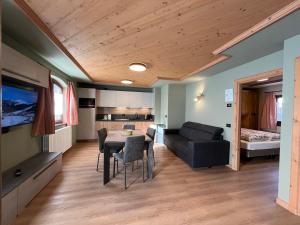una sala de estar con una mesa y un sofá en Bait da Nicolin - Myholidaylivigno, en Livigno