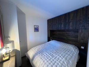 ein Schlafzimmer mit einem Bett mit hölzernem Kopfteil in der Unterkunft Incredible 2 rooms, sun terrace view, slope Incroyable appartement, six personnes Tout, pédestre, commerces et piste, Immense terrasse, vue panoramique montagne et pistes in Isola 2000