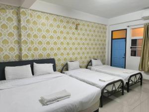 a bedroom with two beds with white sheets at SB Betong GUESTHOUSE in Betong