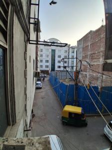 Hotel RS international Couple Friendly في نيودلهي: زقاق ذو سياج أزرق وسيارة صفراء