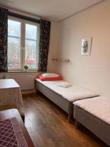 two beds in a room with a window at Torget Vandrarhem in Kävlinge