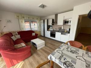a living room with a red couch and a table at Fewo Anders Nr1 in Neue Tiefe Fehmarn