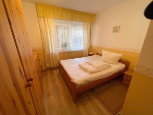 a small bedroom with a bed and a window at Fewo Anders Nr1 in Neue Tiefe Fehmarn