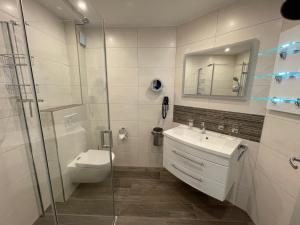 a bathroom with a toilet and a sink and a shower at Fewo Anders Nr1 in Neue Tiefe Fehmarn +3 photos