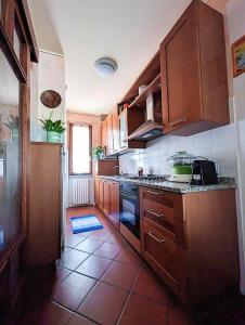 una cucina con armadi in legno e pavimento piastrellato di Photo House Collodi La Villetta a Collodi