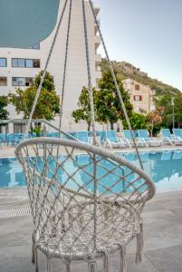 una sedia a dondolo davanti a una piscina di Montenegrina Hotel & SPA All-Inclusive a Bečići