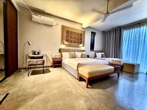 a bedroom with a bed and a desk and a chair at Palm Paradise Cabanas & Villas Beach Resort in Tangalle
