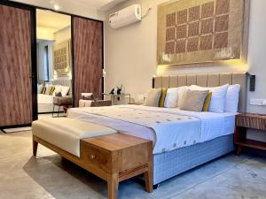 a bedroom with a large bed with a bench in it at Palm Paradise Cabanas & Villas Beach Resort in Tangalle