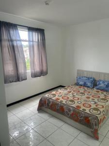 a bedroom with a bed and a window at Coconut House in Albion