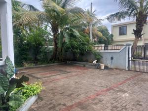 a patio in front of a house with palm trees at Coconut House in Albion