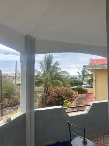 a chair on a balcony with a view of a palm tree at Coconut House in Albion