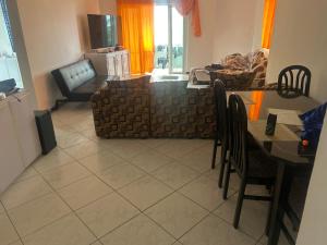 a living room with a couch and a table and chairs at Coconut House in Albion
