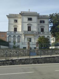 een wit huis met een hek ervoor bij Villa Santoni Guest House in Orte