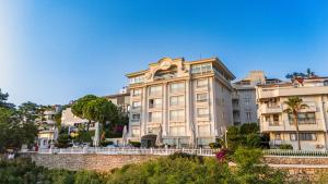 een groot wit gebouw met bomen ervoor bij La Boutique Hotel & Suites - Adults Only in Antalya