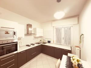 ヴェネツィアにあるLeone Di San Marcoのキッチン(茶色のキャビネット、窓付)